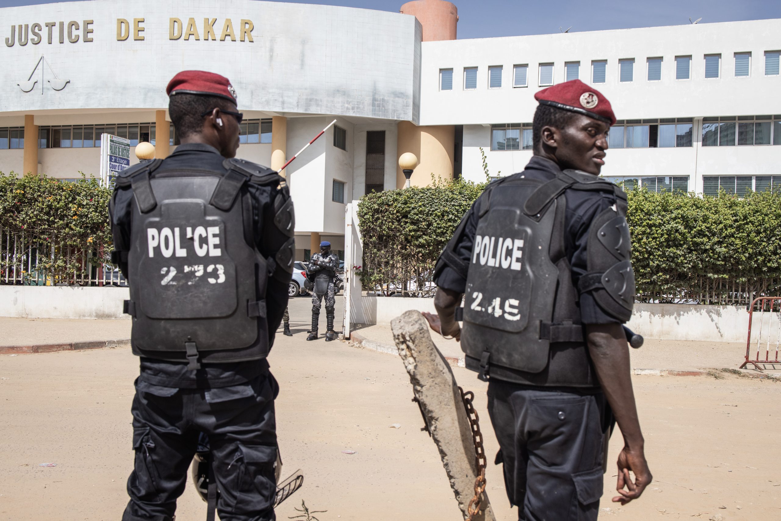 Police officers stand in front of the court house where Opposition leader Ousmane Sonko is appearing in front of a judge for a hearing in Dakar on November 03, 2022, for his alleged rape case against Adji Sarr. (Photo by JOHN WESSELS / AFP)