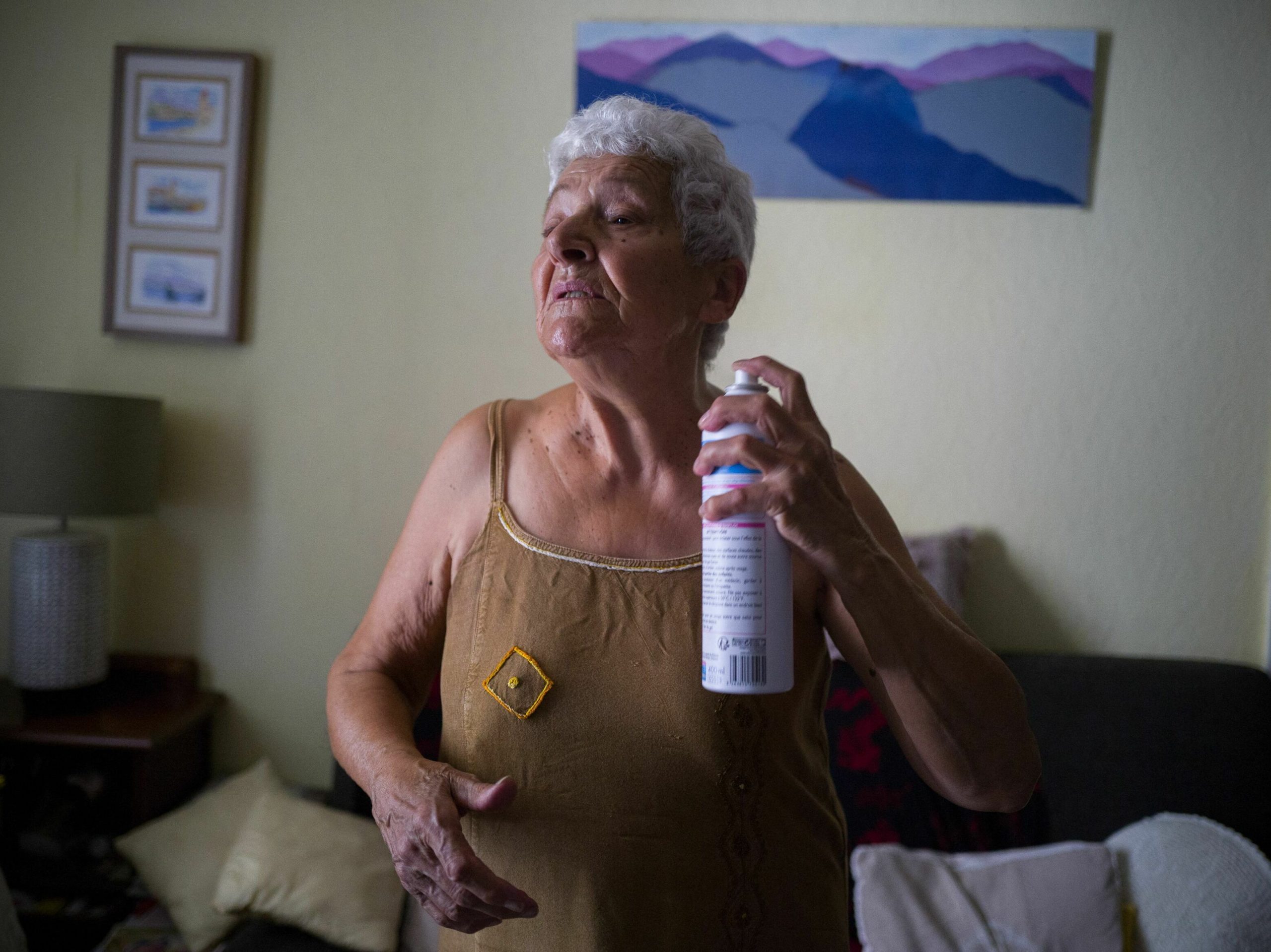 Jackye Lafon, an 81-year-old retiree, refreshes herself with a water spray in her flat of the Cite Bourbaki in the Minimes district of Toulouse on July 14, 2022. - France is witnessing a second heatwave in less than a month, "a sign of climate change and hotter summers to come where 35 degrees will be the norm" said the French weather broadcast company Meteo France. (Photo by FRED SCHEIBER / AFP) (Photo by FRED SCHEIBER/AFP via Getty Images)